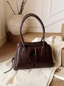 Minimalist dark brown leather Boston bag with stylish knot handle in a retro aesthetic