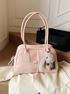 Chic pink Boston shoulder bag with plush bunny charm on soft home carpet setting