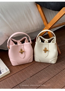 Close-up of retro leather bucket bags in pink and beige with golden metal clasps