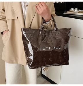 Detail of large tote bag featuring glossy transparent finish over brown snakeskin texture