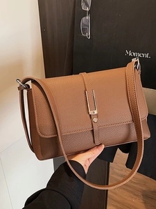 Brown litchi grain leather shoulder bag with silver buckle in a stylish setup