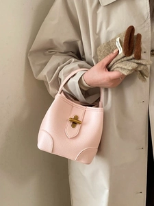 Pink lychee grain leather bucket bag with gold turn-lock and soft handle strap