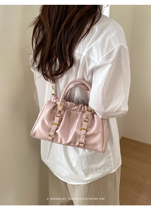 Close-up of pink patent leather ruched handbag with gold hardware and retro handle