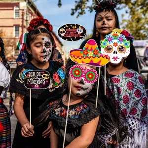Close-up of Day of the Dead photo props featuring sugar skull masks and flower crowns