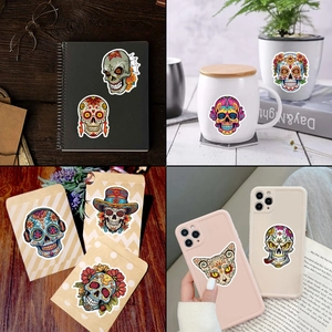 Sugar skull decorative stickers shown on laptop and mug for Day of the Dead party