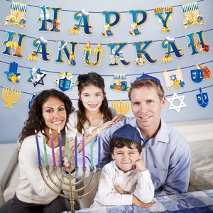 Family lighting Menorah with Happy Hanukkah banner and Star of David party decorations