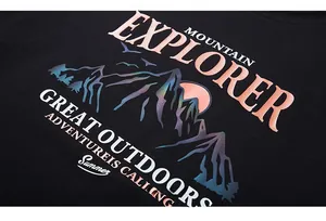 Close-up of holographic gradient mountain print on a black oversized cotton t-shirt