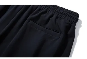 Close-up of the elastic waistband and rear welt pocket on black cotton sports shorts