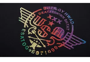 Gros plan de l'imprimé pailleté USA et dégradé arc-en-ciel sur le t-shirt noir ample