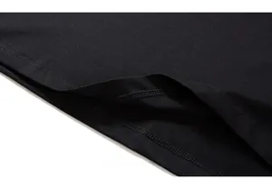 Close-up of double-stitched hem and fine fabric texture on the black cotton T-shirt
