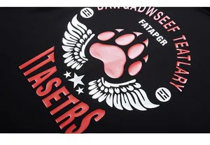 Detail of pink paw print and silver wings graphic on black cotton oversized t-shirt