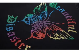 Détail macro du papillon pailleté arc-en-ciel et texte gothique sur t-shirt en coton noir