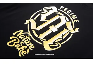 Dettaglio ravvicinato della stampa dorata metallizzata su tessuto nero della t-shirt