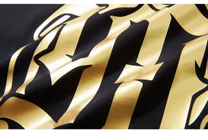 Dettaglio della stampa gotica in oro metallizzato su tessuto di cotone nero della t-shirt