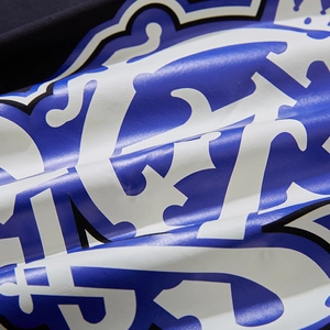 Detail of high-quality blue and white screen printing on a black cotton oversized t-shirt