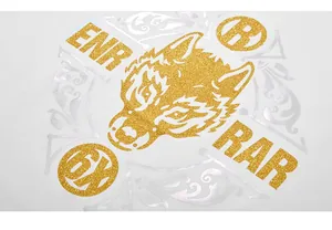 Détail macro de l'imprimé loup doré pailleté et motifs argentés sur t-shirt blanc