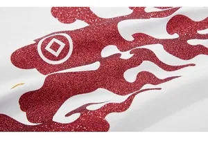 Macro shot of red glitter flame print with circular symbol on white cotton t-shirt