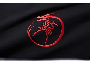 Macro shot of red Chinese dragon embroidery on black knit fabric of an oversized T-shirt
