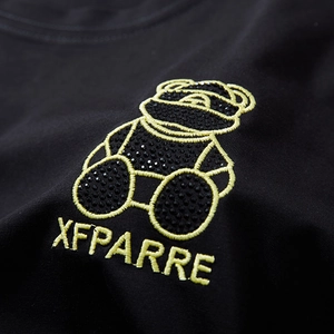Oversized black cotton T-shirt featuring a teddy bear with rhinestones and yellow embroidery