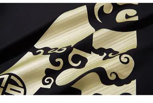 Macro view of gold carbon fiber texture and traditional pattern print on black T-shirt fabric