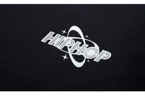 Detail of silver glitter HIPHOP print with stars on black oversized sweatshirt fabric