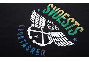 Close-up of glittery gradient print with nautical anchor design on black cotton T-shirt