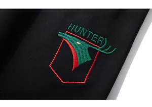 Detailed macro view of HUNTER embroidery and tricolor shield on black fabric