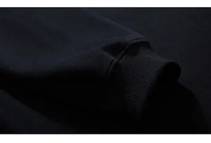 Macro detail of elastic ribbed cuffs on black oversized cotton long sleeve sweatshirt