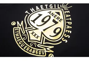Vue macro du motif as de pique doré et de la typographie artistique sur tissu en coton noir