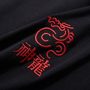 Oversized black cotton T-shirt featuring intricate red Chinese dragon embroidery