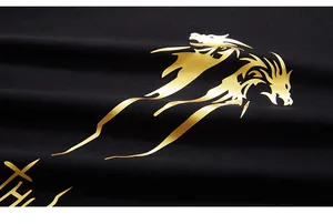Detail of premium black knit fabric with luxury gold foil dragon print and metallic texture