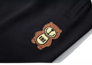 Gros plan détaillé du tissu noir tricoté avec broderie d'ours brun et texte ERE