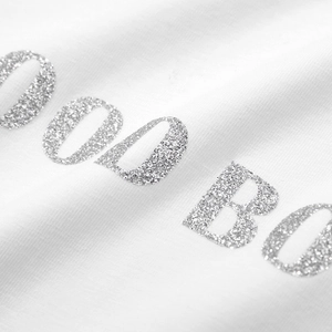 White oversized t-shirt featuring silver glitter letter print and cotton texture