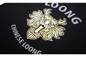 Close-up of golden Chinese dragon print and silver glitter lettering on a black t-shirt