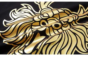 Close-up of golden dragon pattern foil print on black oversized cotton t-shirt fabric