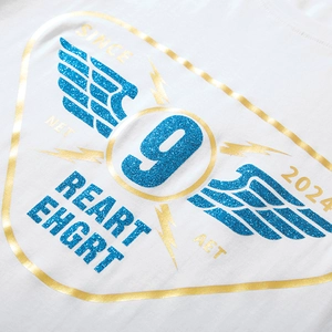 White oversized T-shirt featuring shimmering blue wings and gold glitter graphic print