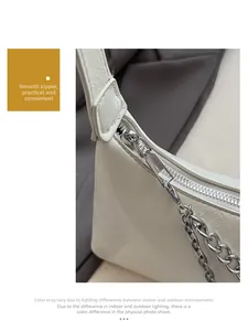 Detail of creamy white PU leather texture with silver metal zipper and decorative chain