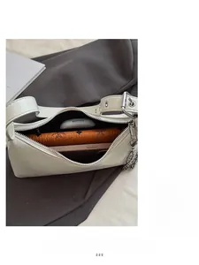 Close-up of beige glossy baguette bag interior showing space for phone and wallet