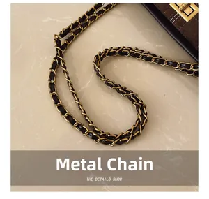 Close-up of golden hardware chain and metallic twist lock on vintage tote bag