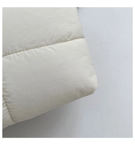 Macro shot of white quilted fabric texture with horizontal stitching on large tote bag