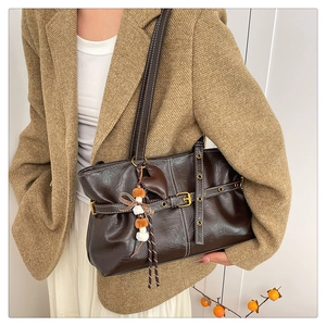 Detail of vintage brown tote bag with contrast stitching and heart-shaped pendant