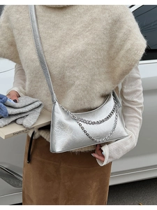 Silver metallic pleated crossbody bag with double chain detail shown on a model