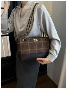 Close-up of brown checkered tote bag with gold twist lock and leather chain strap