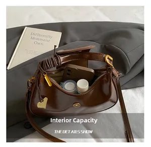 Macro view of retro brown moon bag interior capacity showing phone and cosmetics