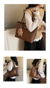 Detail of vintage brown leather tote bag featuring a cute teddy bear charm accessory