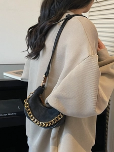 Sac croissant noir chic avec finition mate et détail de chaîne dorée audacieuse