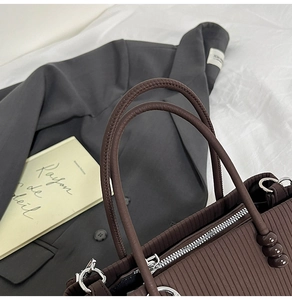 Détails rapprochés d'un sac cabas marron foncé avec texture côtelée et perles déco