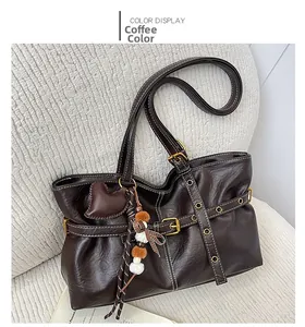 Detail of coffee brown vintage tote bag with contrast stitching and decorative charms