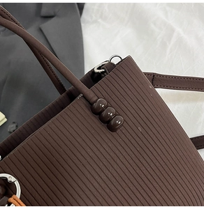 Détail du sac fourre-tout plissé marron foncé avec perles et boucles argentées