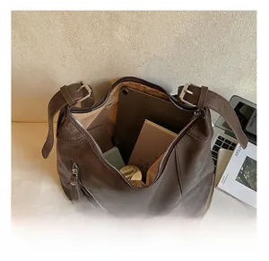 Gros plan montrant l'intérieur spacieux d'un grand sac cabas vintage en cuir marron